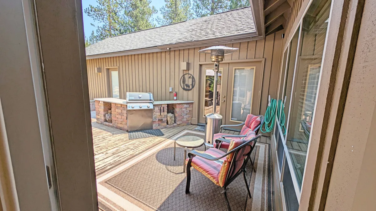 An inviting outdoor seating area on the patio, complete with a grill and patio heater. The setup encourages small group gatherings, with ample space for relaxing or barbecuing after a day of activities. You can see the seating is arranged for socializing, with the grill ready for use, and the patio heater suggesting comfort in any weather.