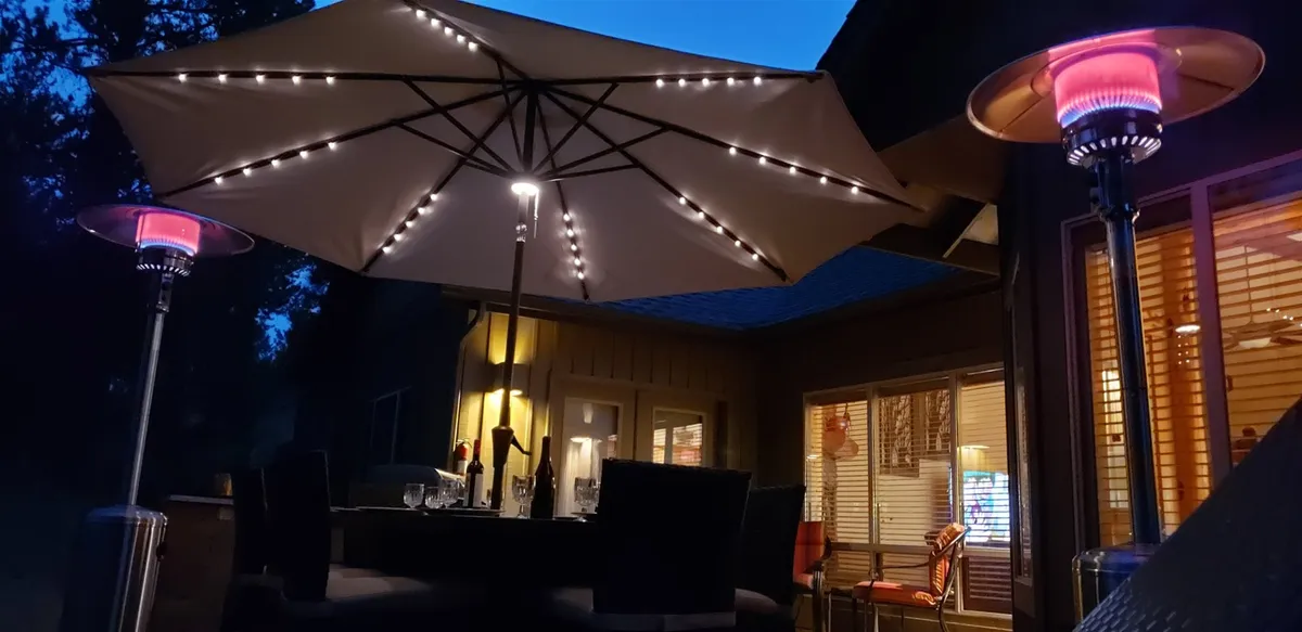 The image features an evening patio scene with an illuminated umbrella, patio heaters, and a relaxed outdoor seating area. It captures the ambiance of al fresco gatherings, with family and friends enjoying the outdoors under the stars.